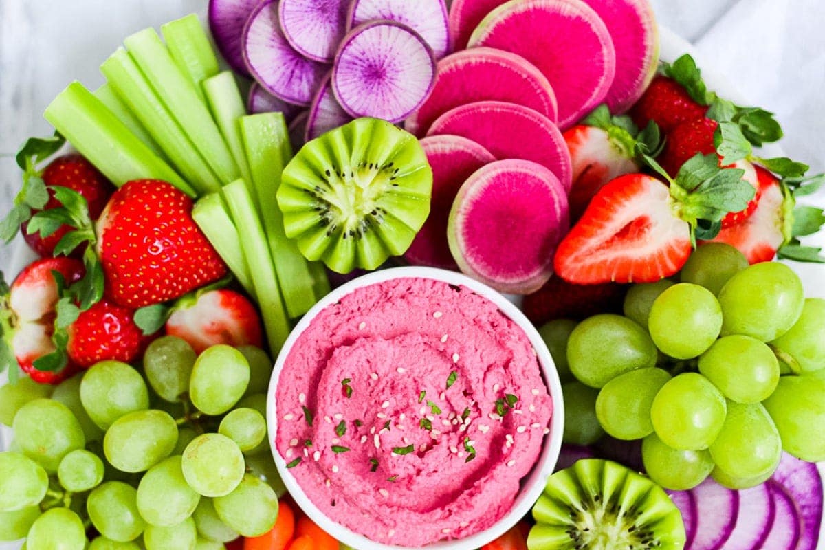 Snack Board filled with fruits, vegetables, and pink beet hummus