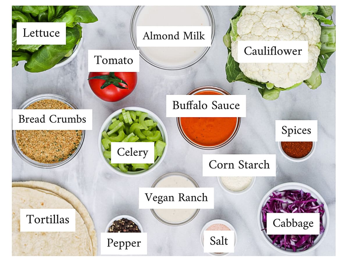 A picture of labeled ingredients: lettuce, bread crumbs, tortillas, tomatoes, celery, pepper, almond milk, buffalo sauce, vegan ranch, corn starch, salt, cauliflower, spices, and cabbage