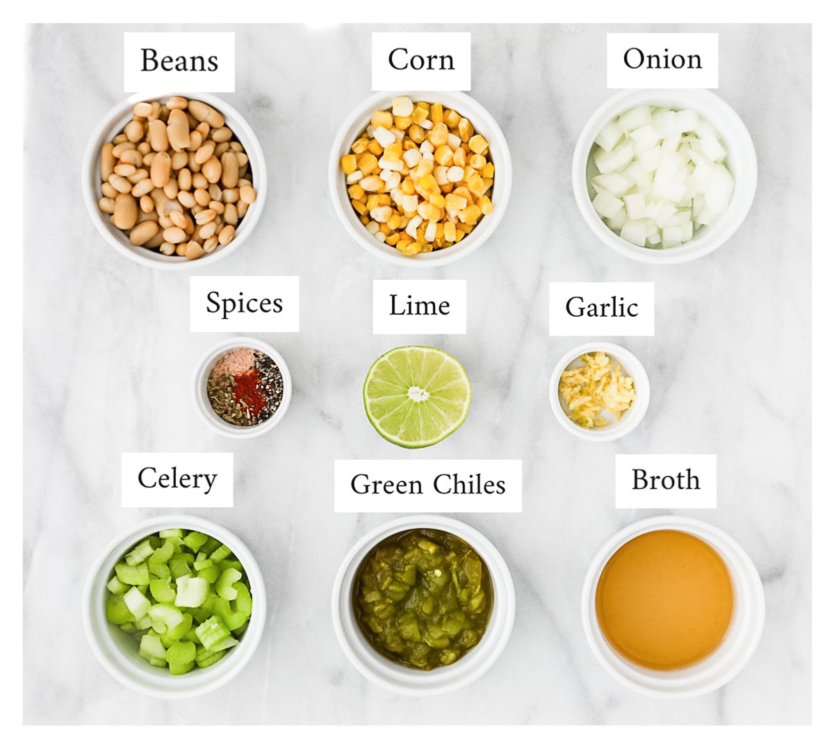 Small white bowls filled with labeled ingredients including: beans, corn, onion, spices, lime, garlic, celery, green chiles, and broth.