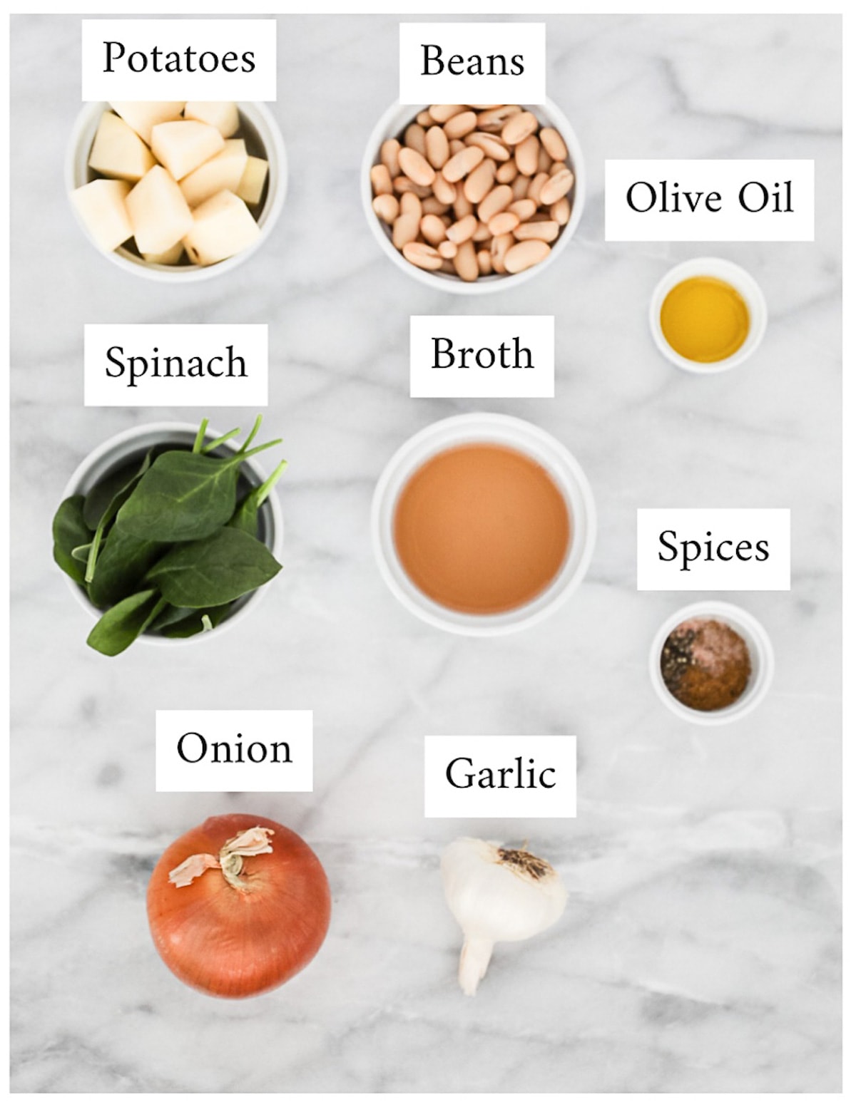 Labeled ingredients in small white dishes including: potatoes, beans, olive oil, spinach, broth, spices, onion, garlic.