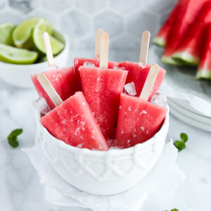 A white bowl filled with crushed ice and watermelon pops.