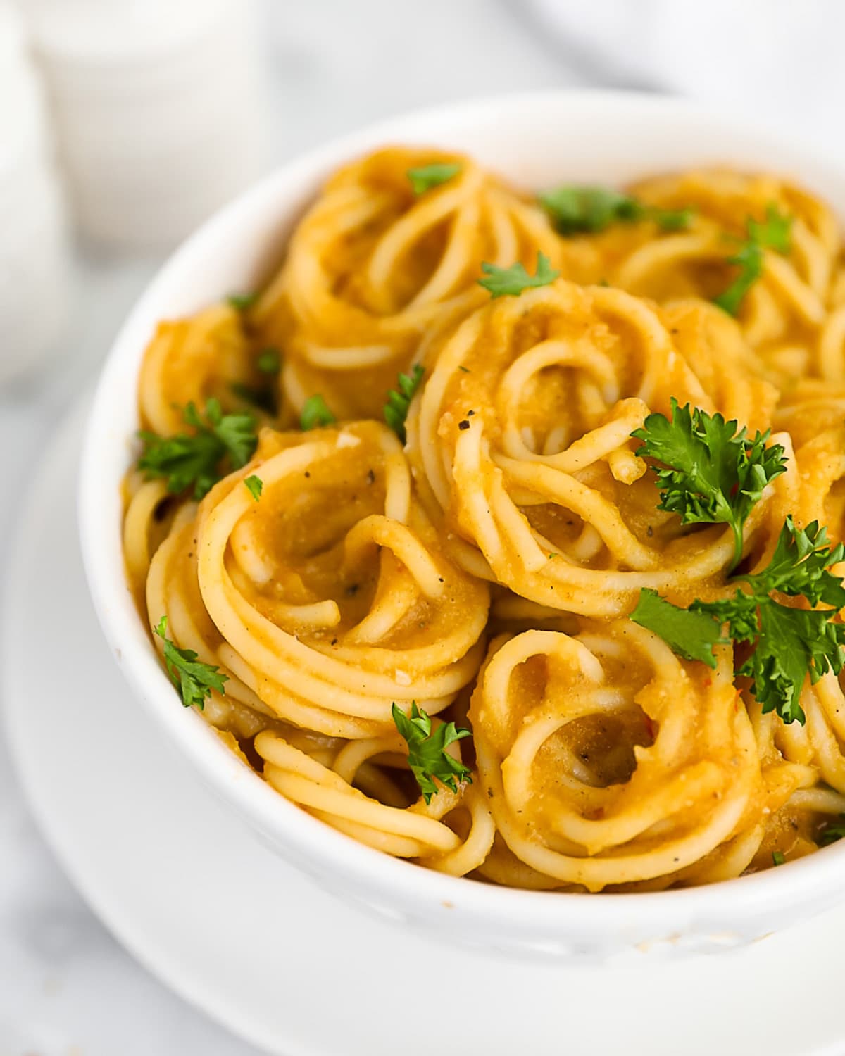 A close up shot of creamy squash sauce and spaghetti noodles