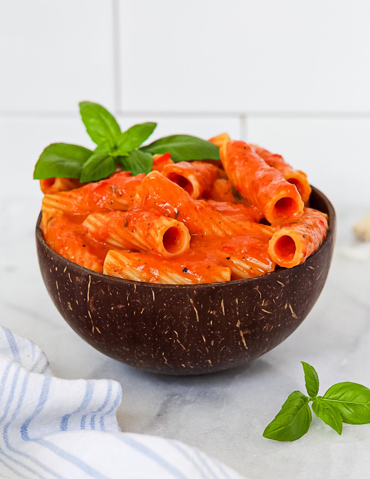 A side angle picture of noodles covered in a red pasta sauce.