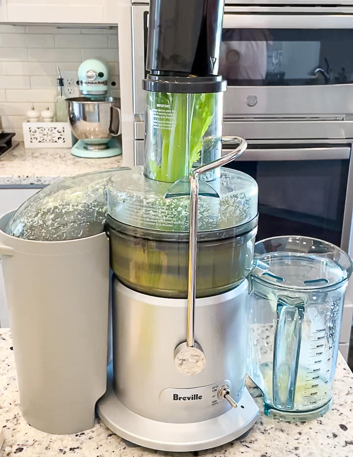 A juicer juicing a large stalk of celery