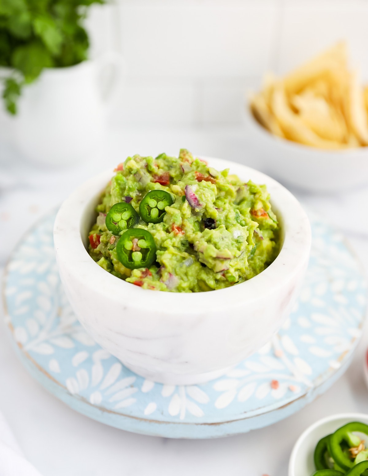 A picture of homemade guacamole in a white marble bowl.