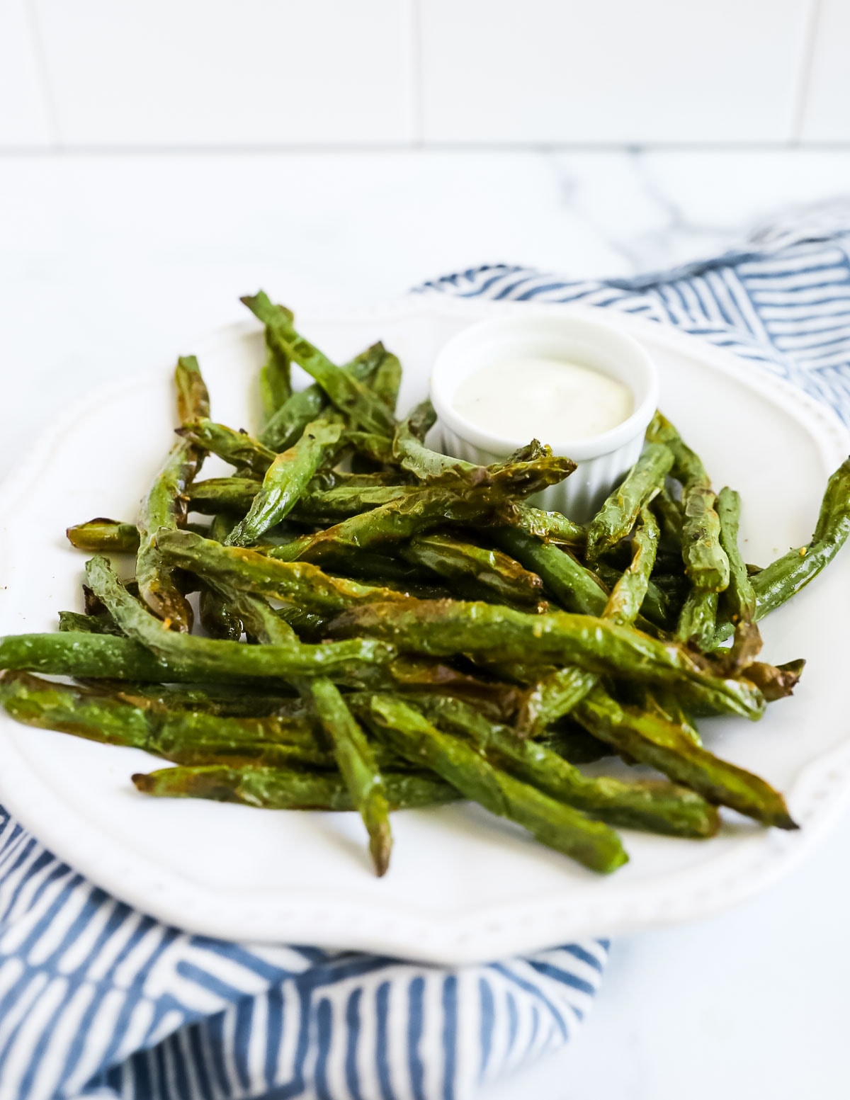 A white plate filled with air fryer green beans.