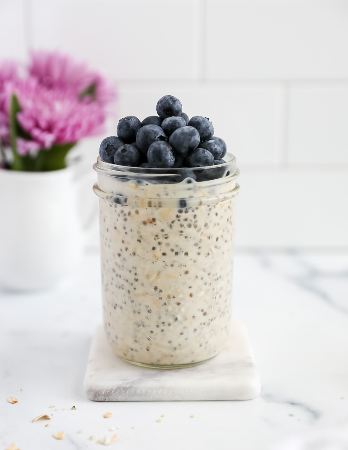 A side shot of oats in a jar with blueberries on top