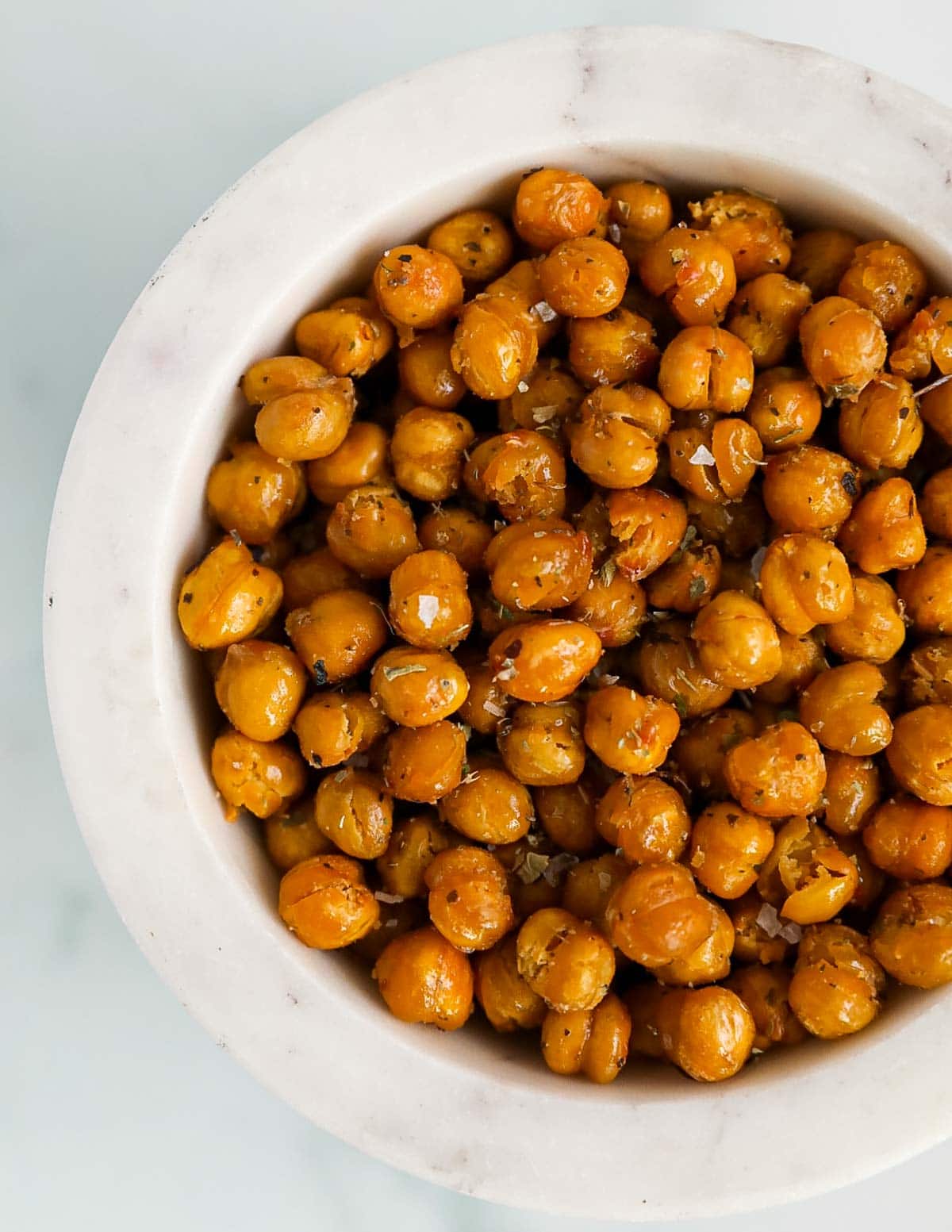 A close up image of roasted chickpeas in a white bowl