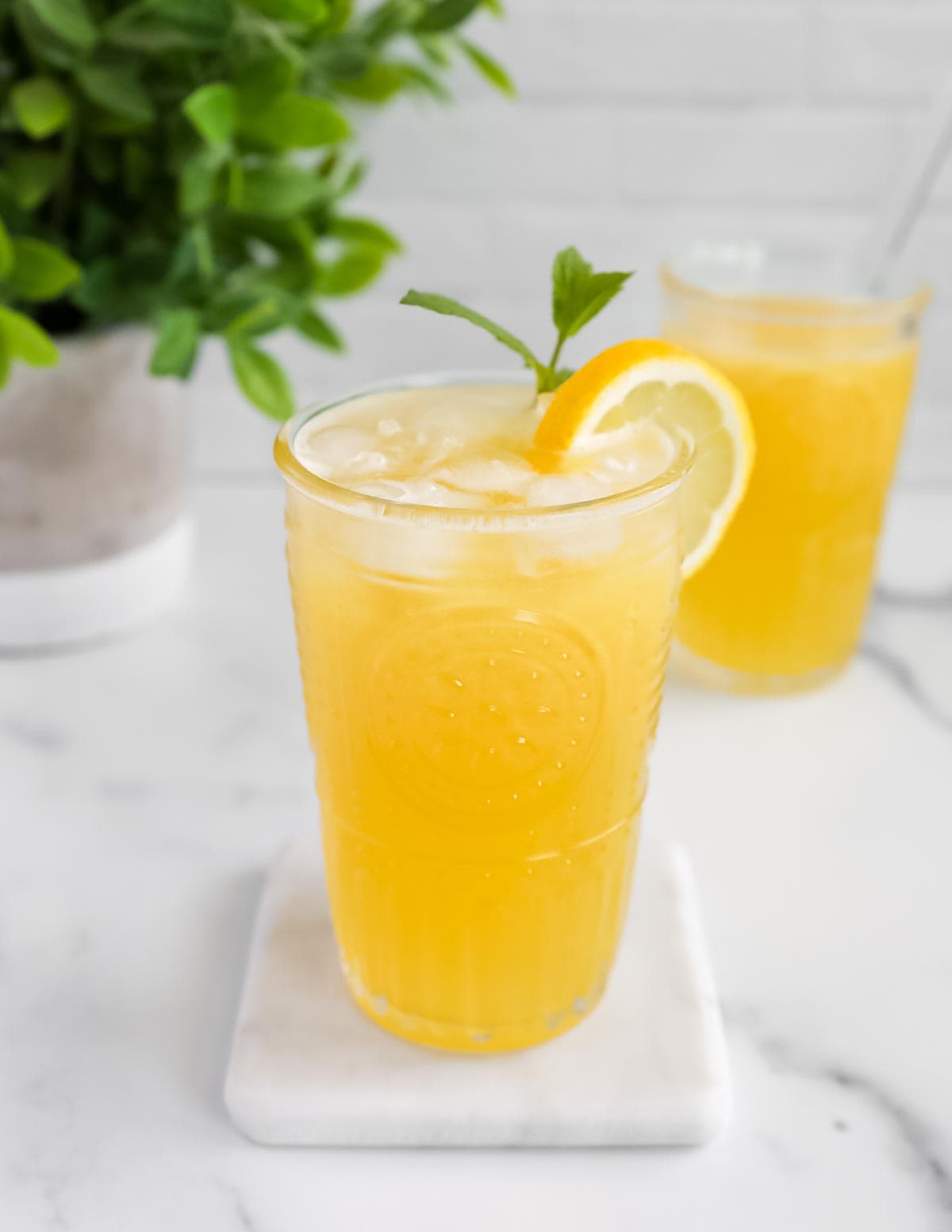 A clear glass filled with yellow lemonade