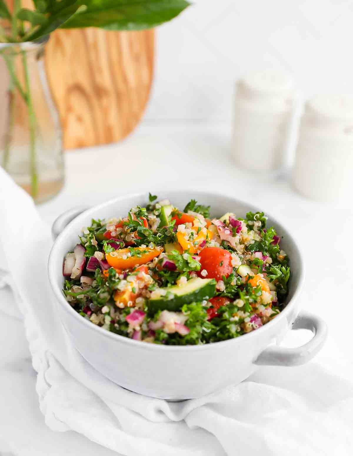 An image of tabouli including colorful tomatoes, parsley, cucumbers, onion, and quinoa