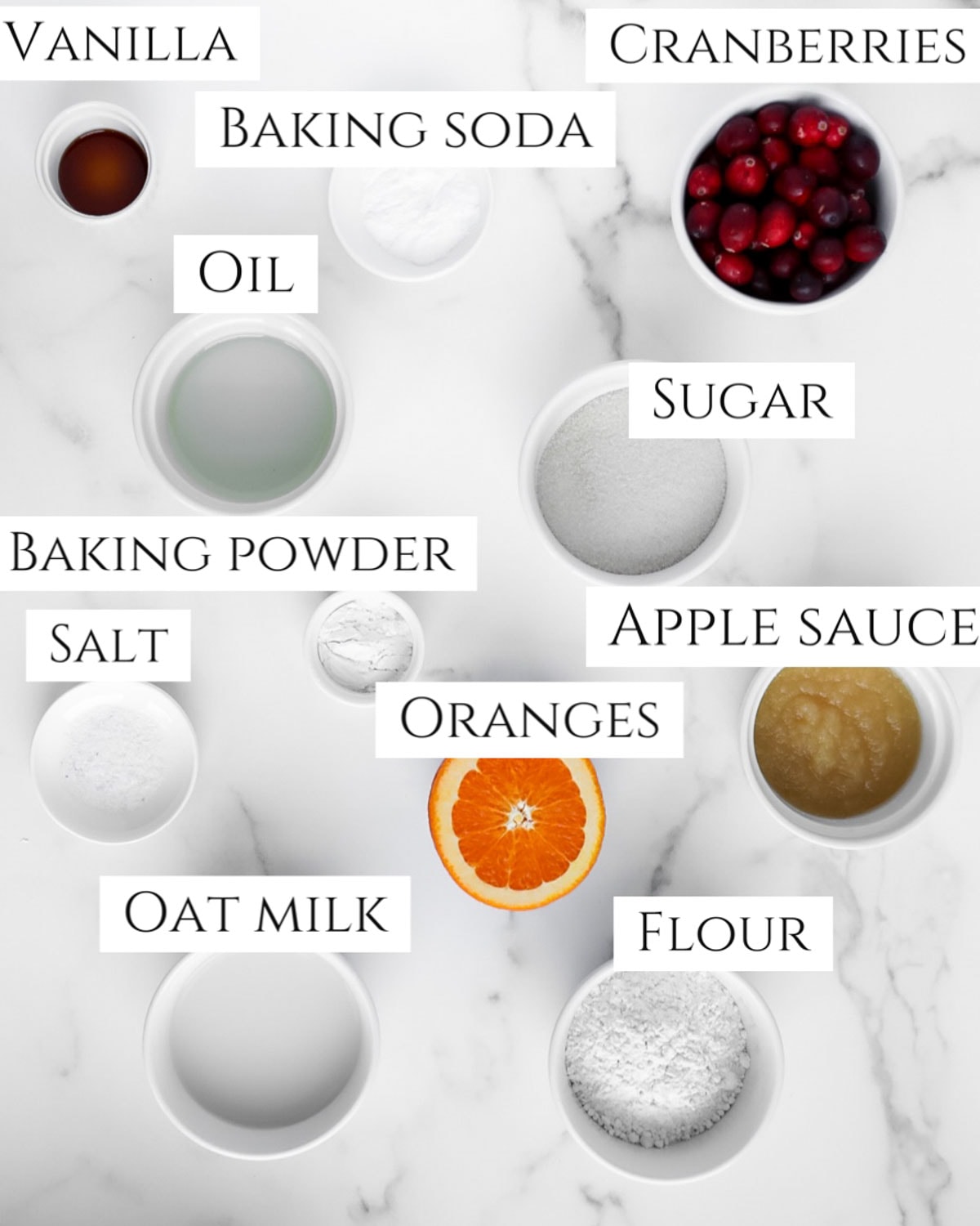 Labeled ingredients including, vanilla, cranberries, baking soda, oil, sugar, baking powder, salt, apple sauce, oranges, oat milk, flour.