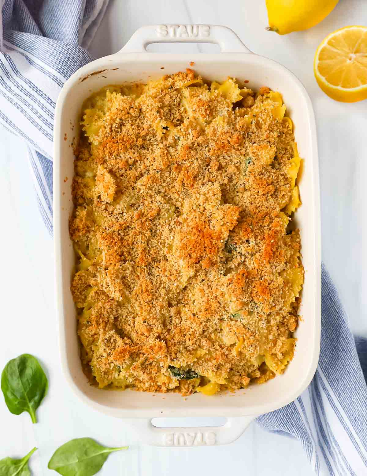 A white baking dish filled with pasta that is topped with toasted bread crumbs.