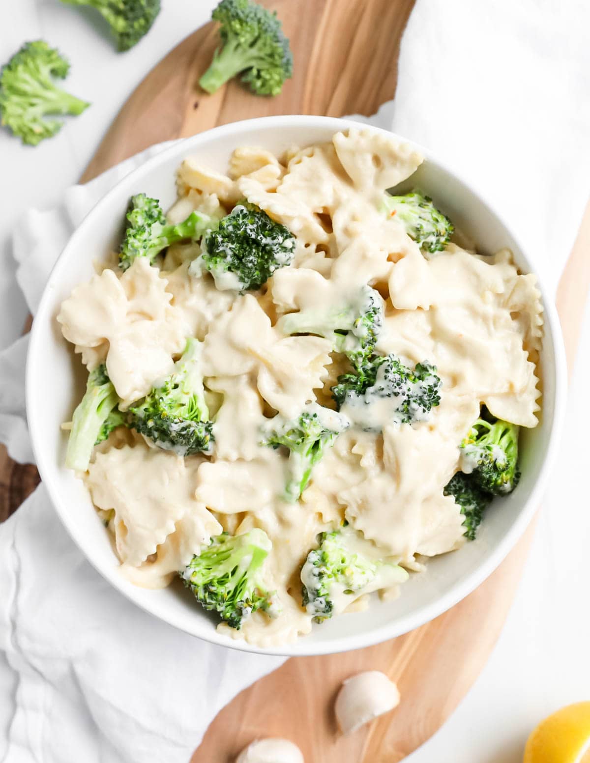 A bowl filled with creamy pasta with broccoli florets.