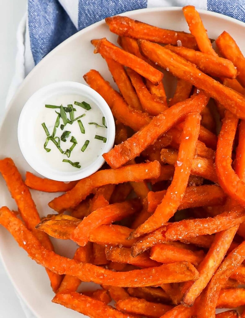 Crispy sweet potato fries and ranch dressing on a plate.