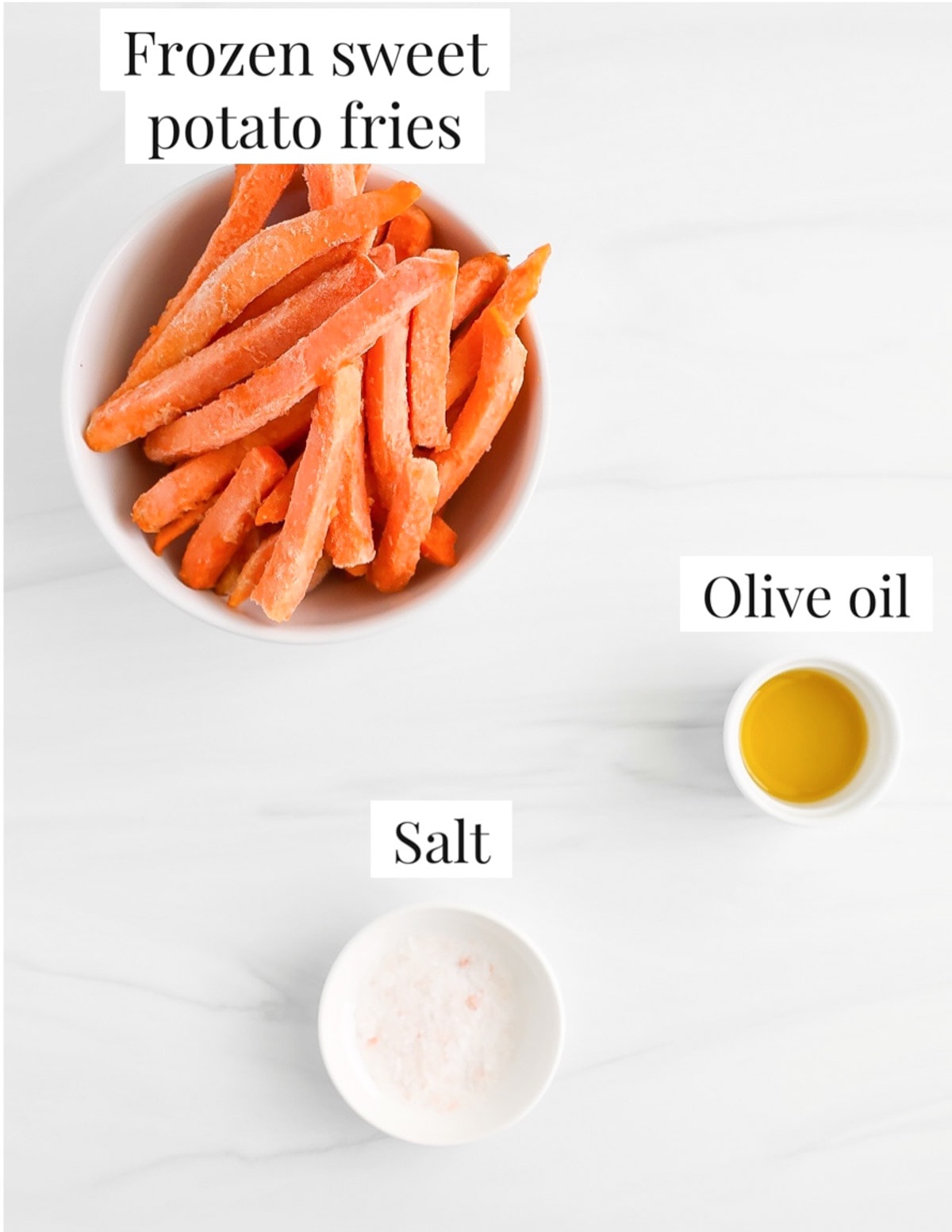 Ingredients in white bowls including: frozen sweet potato fries, olive oil, salt.