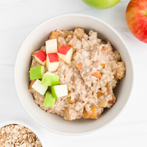 Cooked apples in oatmeal topped with fresh apples.