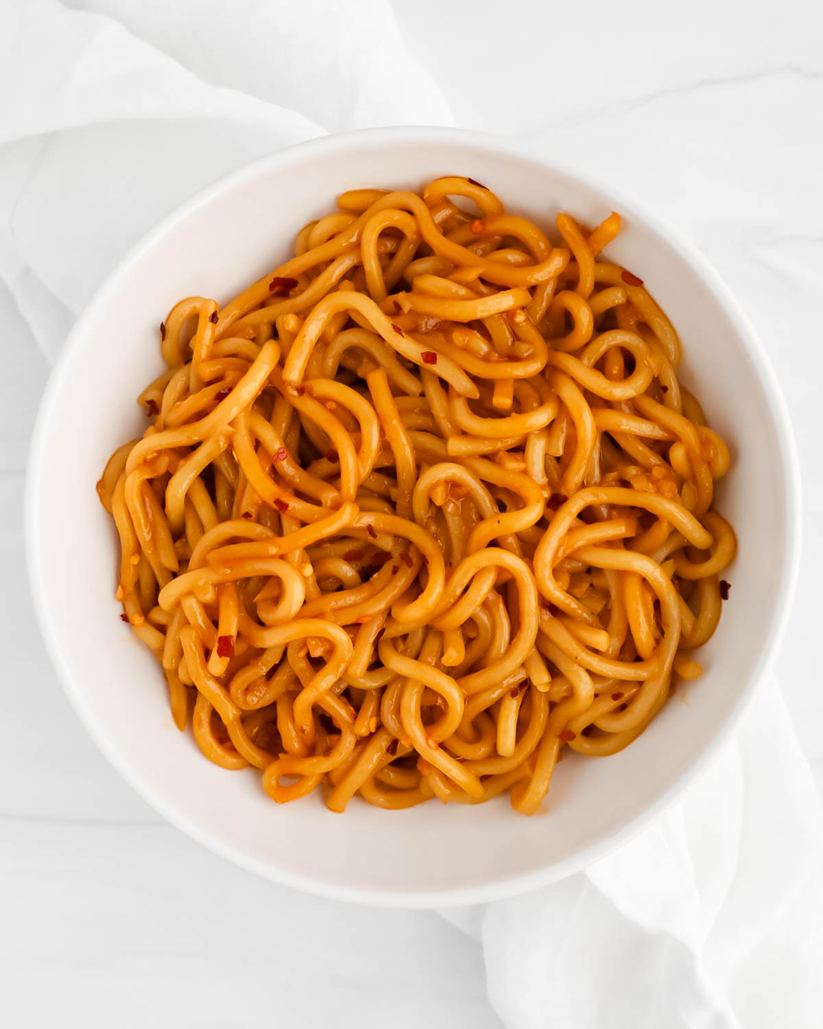 Cooked noodles tossed in a brown sauce.