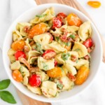 A bowl of pesto tortellini salad covered in a creamy pesto dressing.