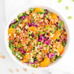 Peanut mandarin orange salad with fresh lettuce, cabbage, carrots, edamame, oranges, and sesame seeds.