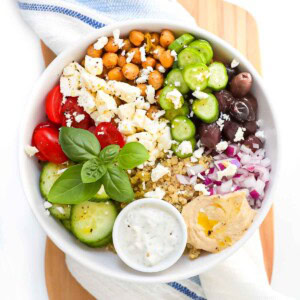 Greek salad bowl with hummus and tzatziki.