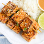 Creamy spicy peanut sauce on tofu satay.